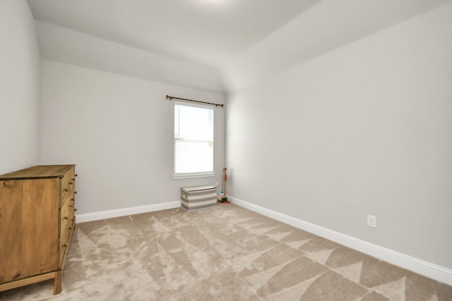 empty room with lofted ceiling and light colored carpet