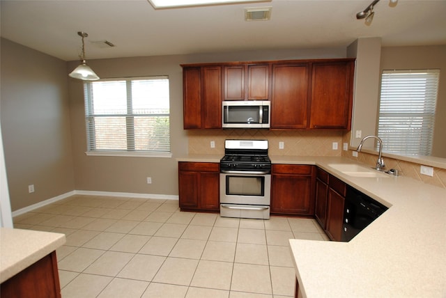 kitchen featuring sink, light tile patterned floors, appliances with stainless steel finishes, pendant lighting, and decorative backsplash