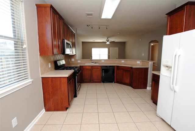 kitchen with sink, ceiling fan, stainless steel appliances, tasteful backsplash, and kitchen peninsula