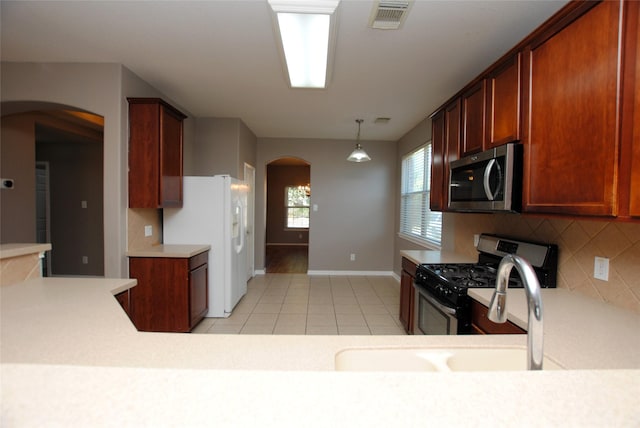 kitchen featuring light tile patterned flooring, sink, backsplash, hanging light fixtures, and stainless steel appliances