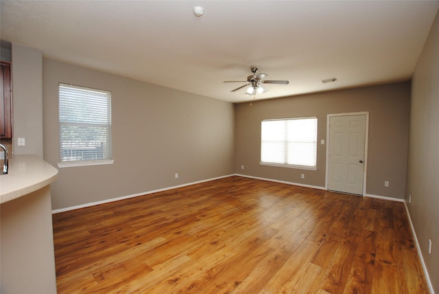 spare room with hardwood / wood-style floors, plenty of natural light, and ceiling fan