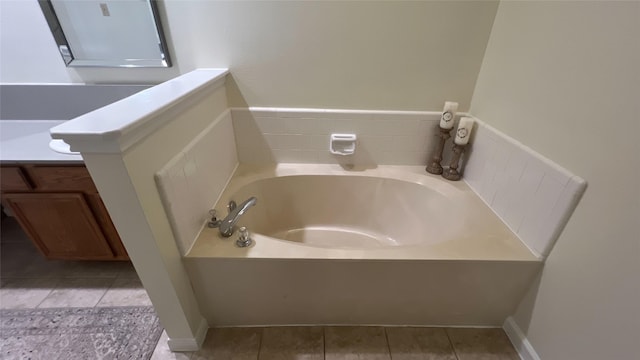 bathroom featuring tile patterned flooring, a garden tub, and vanity