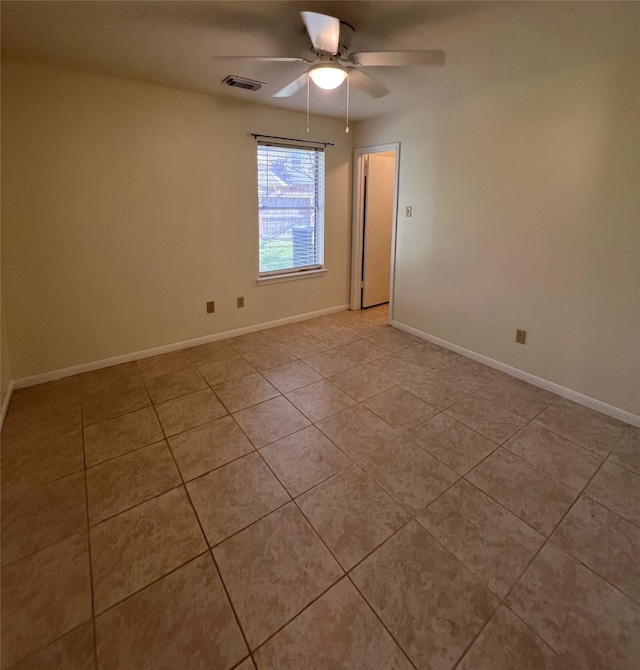 unfurnished room with ceiling fan, light tile patterned floors, visible vents, and baseboards