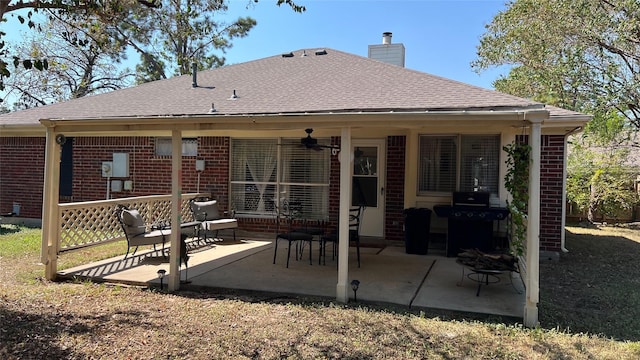 back of house featuring a shingled roof, a chimney, and brick siding