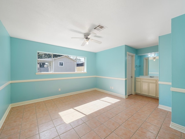 tiled spare room with ceiling fan