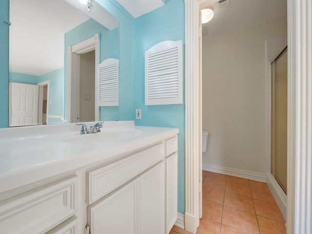 bathroom with vanity, toilet, tile patterned floors, and a shower with shower door