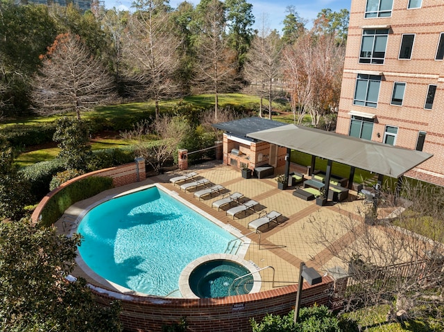 view of swimming pool with exterior bar, exterior fireplace, and a community hot tub