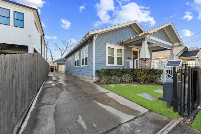 view of front of property with an outdoor structure, crawl space, fence, and a front lawn