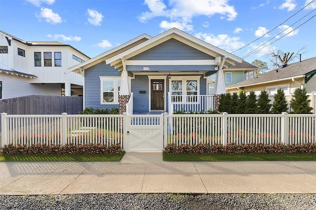 view of front of home featuring covered porch, a fenced front yard, and a gate