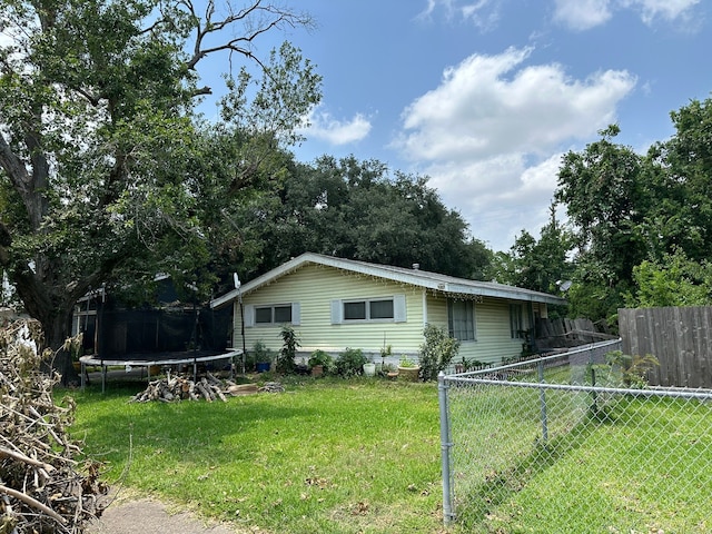 view of front of property featuring a front lawn and a trampoline