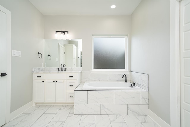 bathroom featuring vanity and tiled bath