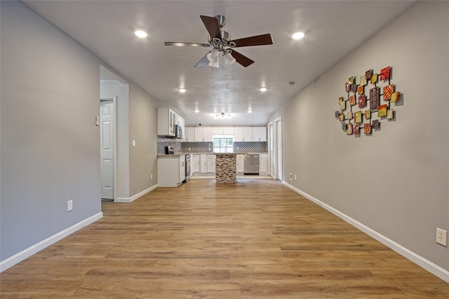 unfurnished living room featuring ceiling fan and light hardwood / wood-style floors