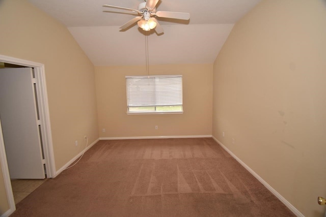 carpeted spare room featuring lofted ceiling and ceiling fan