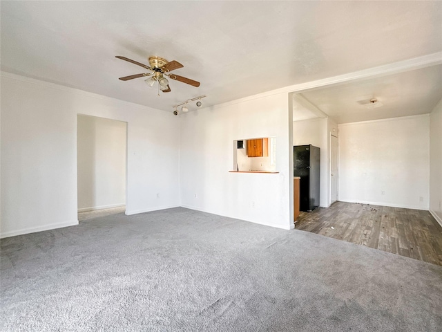 unfurnished living room featuring crown molding, carpet flooring, track lighting, and ceiling fan