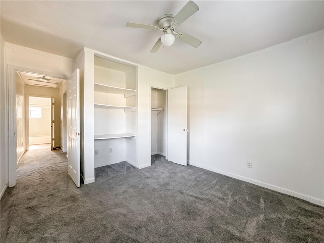 unfurnished bedroom featuring ceiling fan, ornamental molding, dark carpet, and a closet