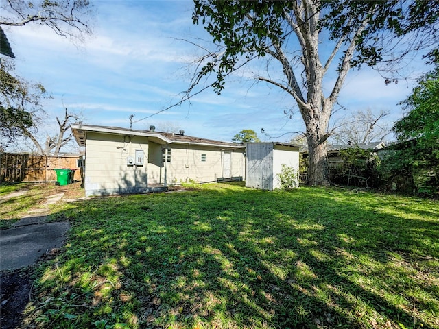 rear view of house featuring a storage unit and a lawn