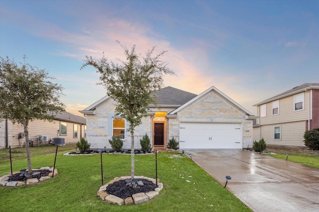 view of front of property with central AC unit, a yard, and a garage