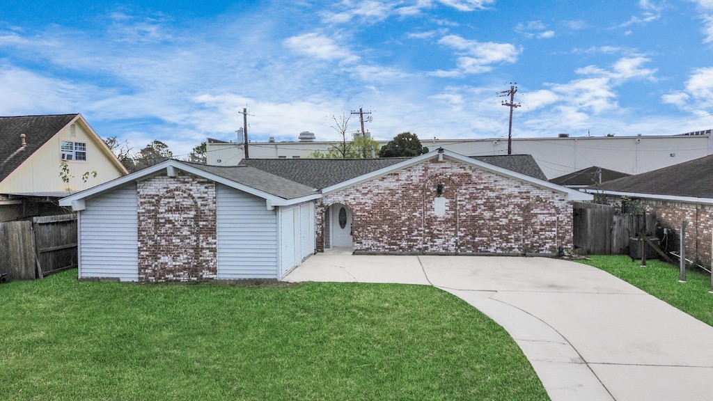 ranch-style house featuring a garage and a front lawn