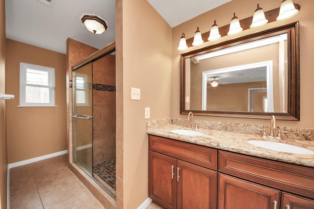 bathroom with a shower with door, vanity, and tile patterned flooring