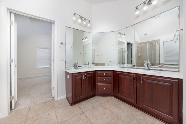 bathroom with vaulted ceiling, vanity, tile patterned floors, and walk in shower