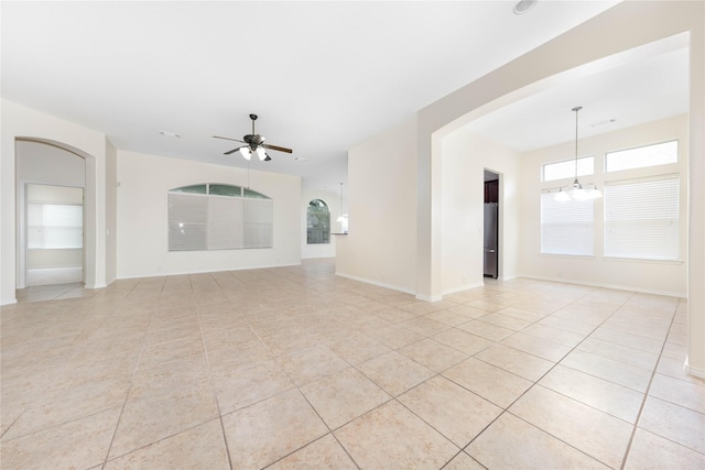 unfurnished living room featuring ceiling fan with notable chandelier and light tile patterned floors