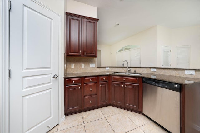 kitchen featuring sink, light tile patterned floors, stainless steel dishwasher, dark stone counters, and decorative backsplash