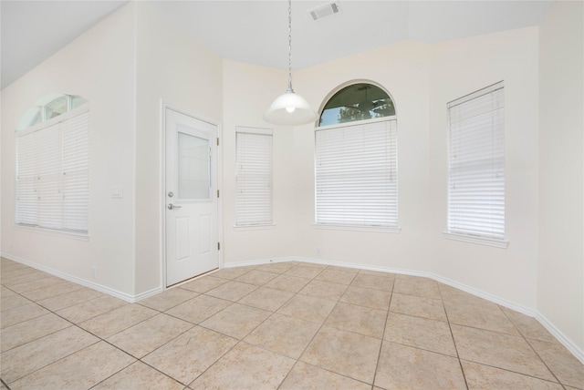 unfurnished dining area featuring vaulted ceiling and light tile patterned flooring