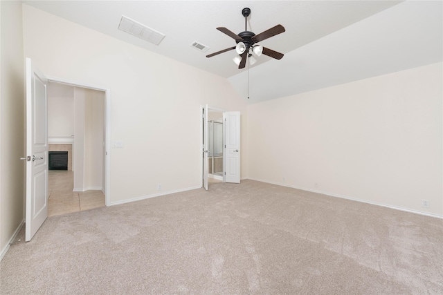 unfurnished bedroom featuring ceiling fan, lofted ceiling, and light carpet