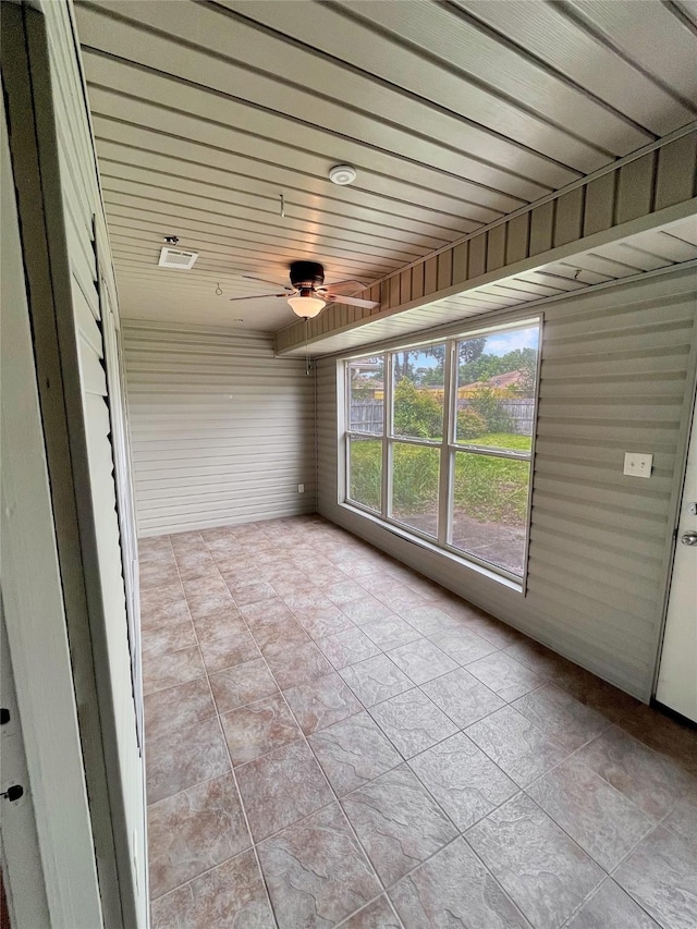 unfurnished sunroom with wooden ceiling and ceiling fan