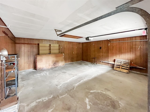 garage featuring a garage door opener and wooden walls