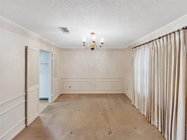 empty room featuring light carpet, ornamental molding, and a chandelier