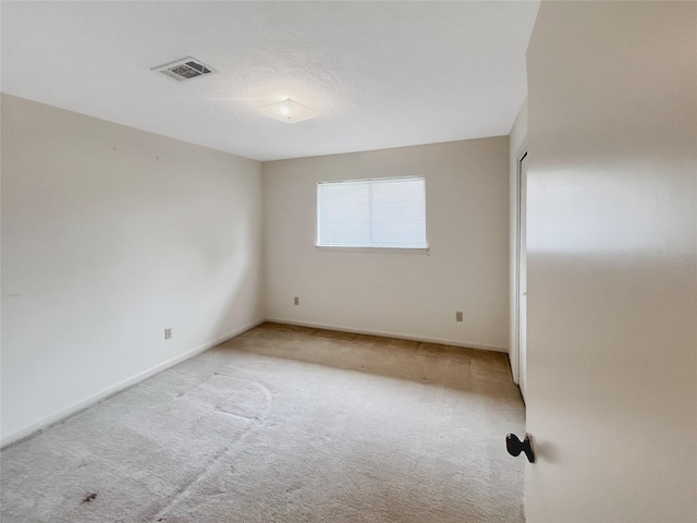 spare room featuring light colored carpet