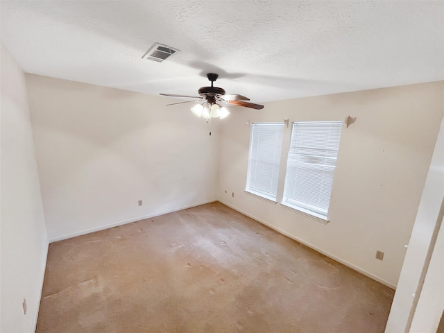 carpeted empty room with ceiling fan and a textured ceiling