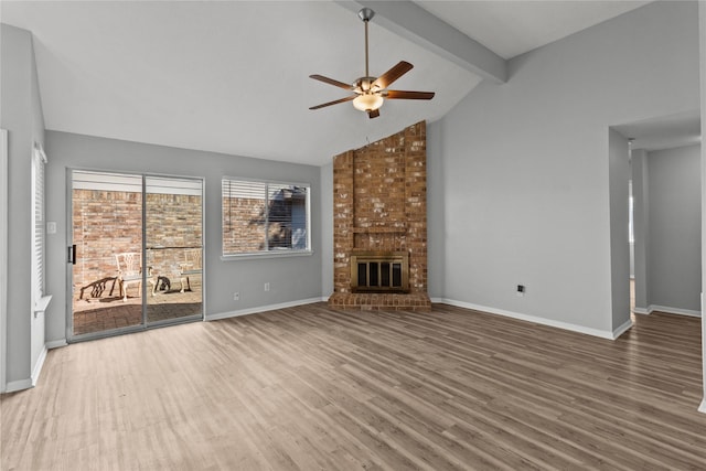 unfurnished living room with hardwood / wood-style floors, a fireplace, lofted ceiling with beams, and ceiling fan