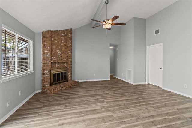 unfurnished living room with a fireplace, vaulted ceiling, wood-type flooring, and ceiling fan