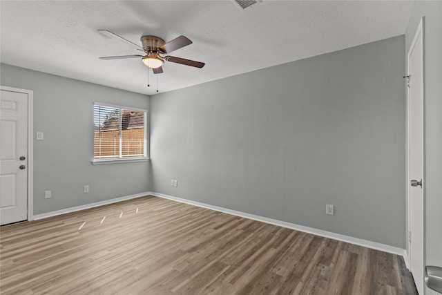 unfurnished room featuring hardwood / wood-style flooring, ceiling fan, and a textured ceiling