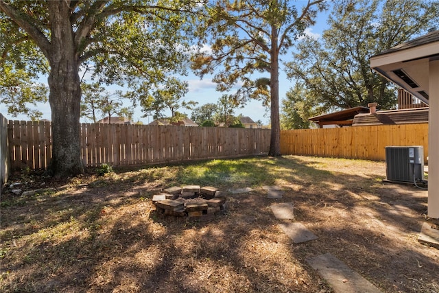 view of yard featuring a fire pit and central AC