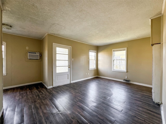 unfurnished room featuring a textured ceiling, dark hardwood / wood-style floors, and a wall mounted AC