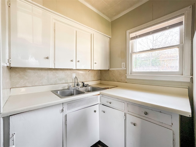 kitchen with white cabinetry, sink, and crown molding