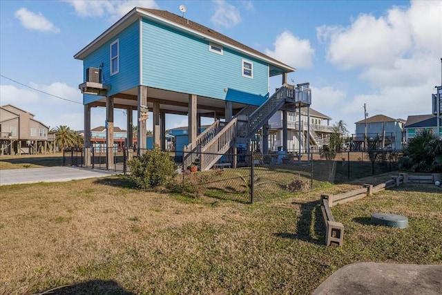 back of property with a carport and a lawn