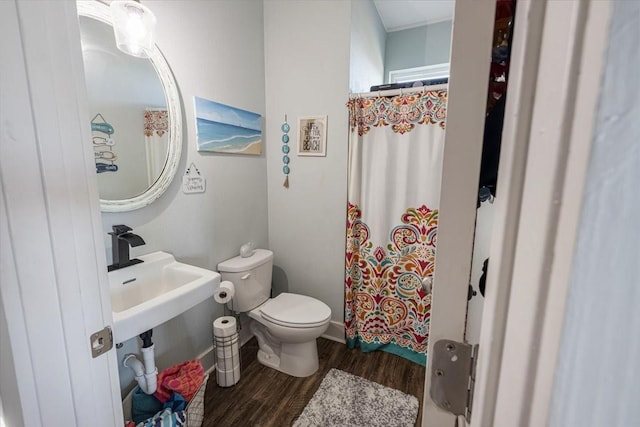 bathroom with wood-type flooring, walk in shower, and toilet