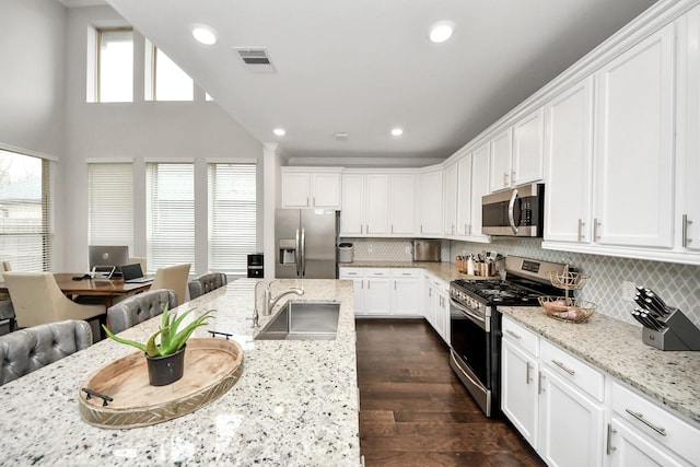 kitchen featuring dark hardwood / wood-style floors, sink, white cabinets, light stone counters, and stainless steel appliances