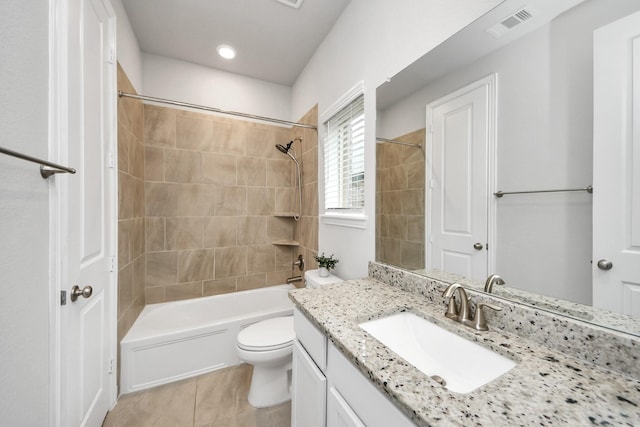 full bathroom featuring vanity, toilet, tiled shower / bath combo, and tile patterned flooring