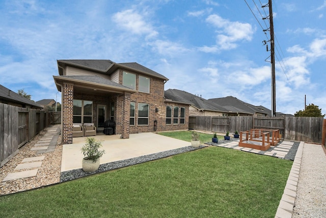 rear view of house with a lawn and a patio