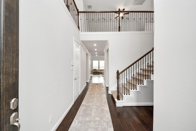 entryway featuring a towering ceiling and dark hardwood / wood-style floors