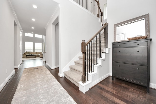 staircase with hardwood / wood-style flooring and ornamental molding