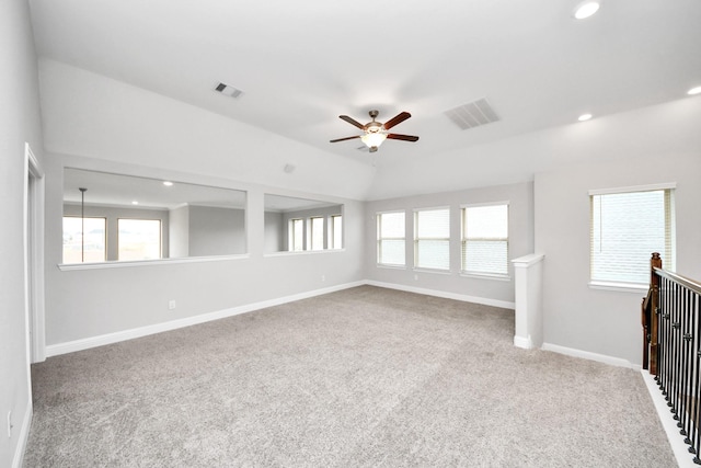 carpeted spare room featuring lofted ceiling and ceiling fan