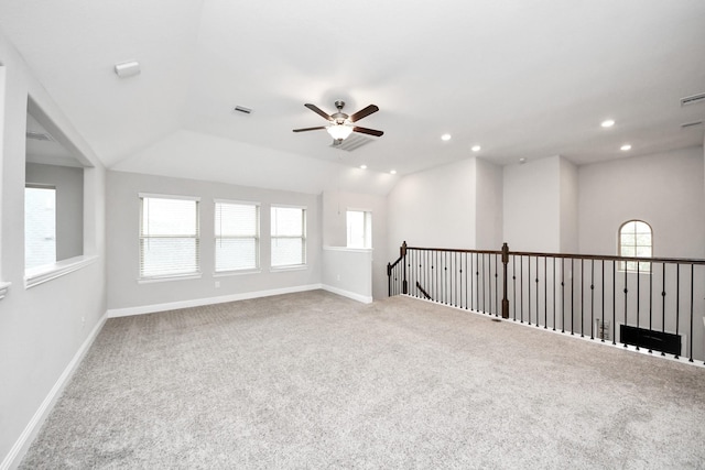 spare room with vaulted ceiling, carpet flooring, and ceiling fan