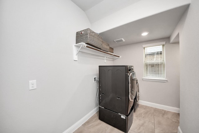 laundry area featuring separate washer and dryer and light tile patterned floors