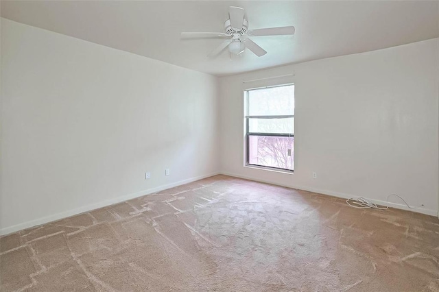 spare room featuring ceiling fan and light carpet